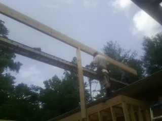 Carpenter setting a ridge beam over a new addition frame — Ice Dam Removal by Roofing Brothers in Kents Store