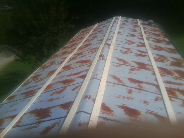 Rusted metal roof panels with new wood purlins before replacement — Storm Damage Roof Repair in Kents Store by Roofing Brothers