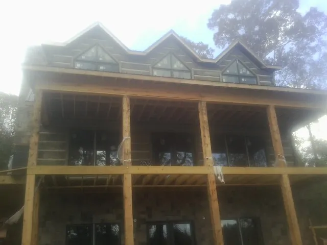 Dormers and porch framing on a large log home under construction — Roof Coating work by our crew in Kents Store