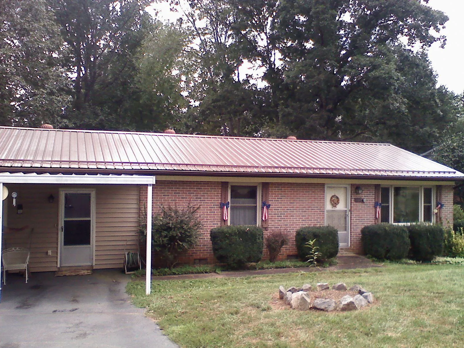 Bronze metal roof and carport on a brick ranch home — Roof Repair work by our crew in Kents Store